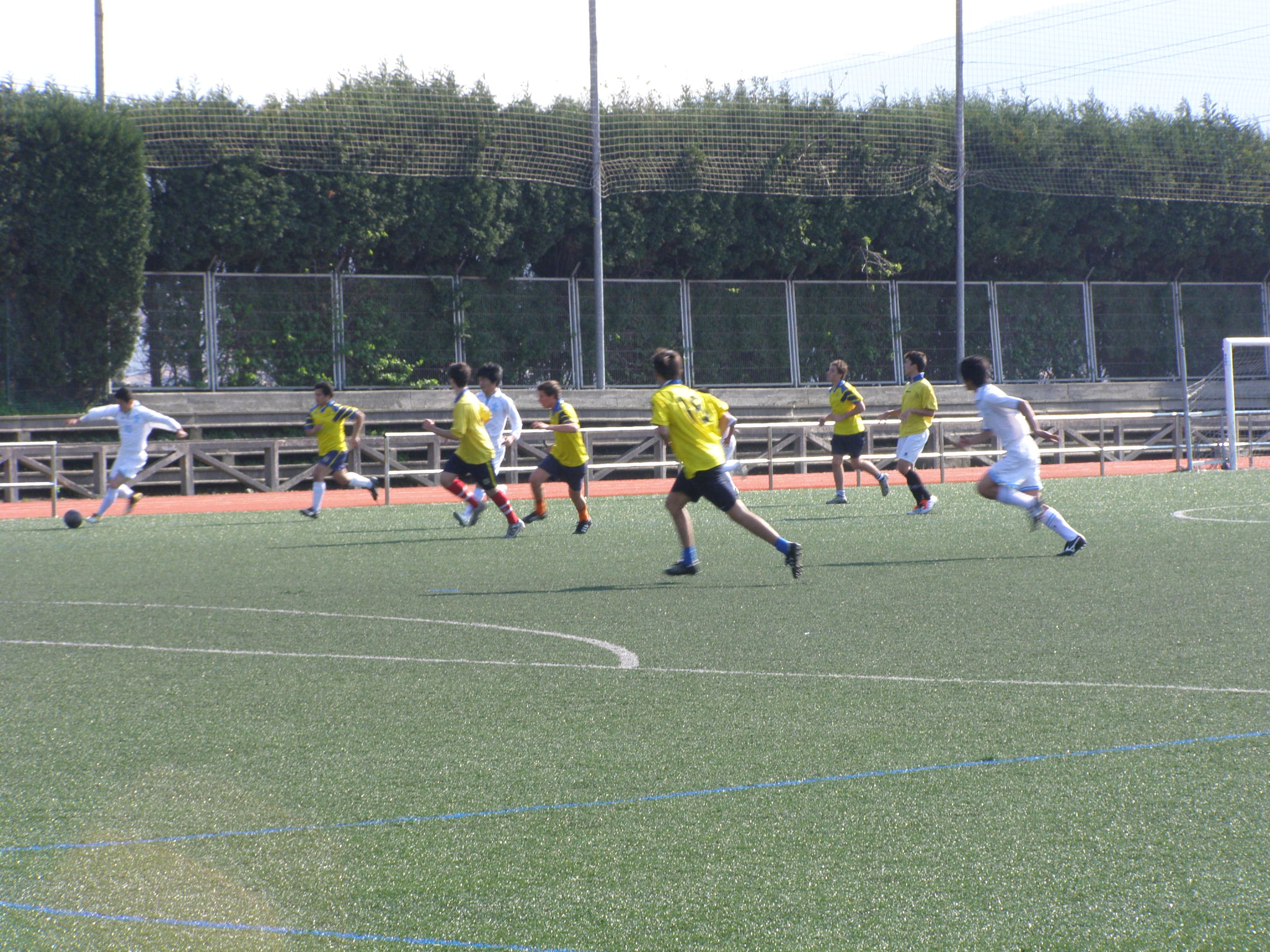 練習試合、黄色と白のユニフォームを着た選手たちの試合中の様子