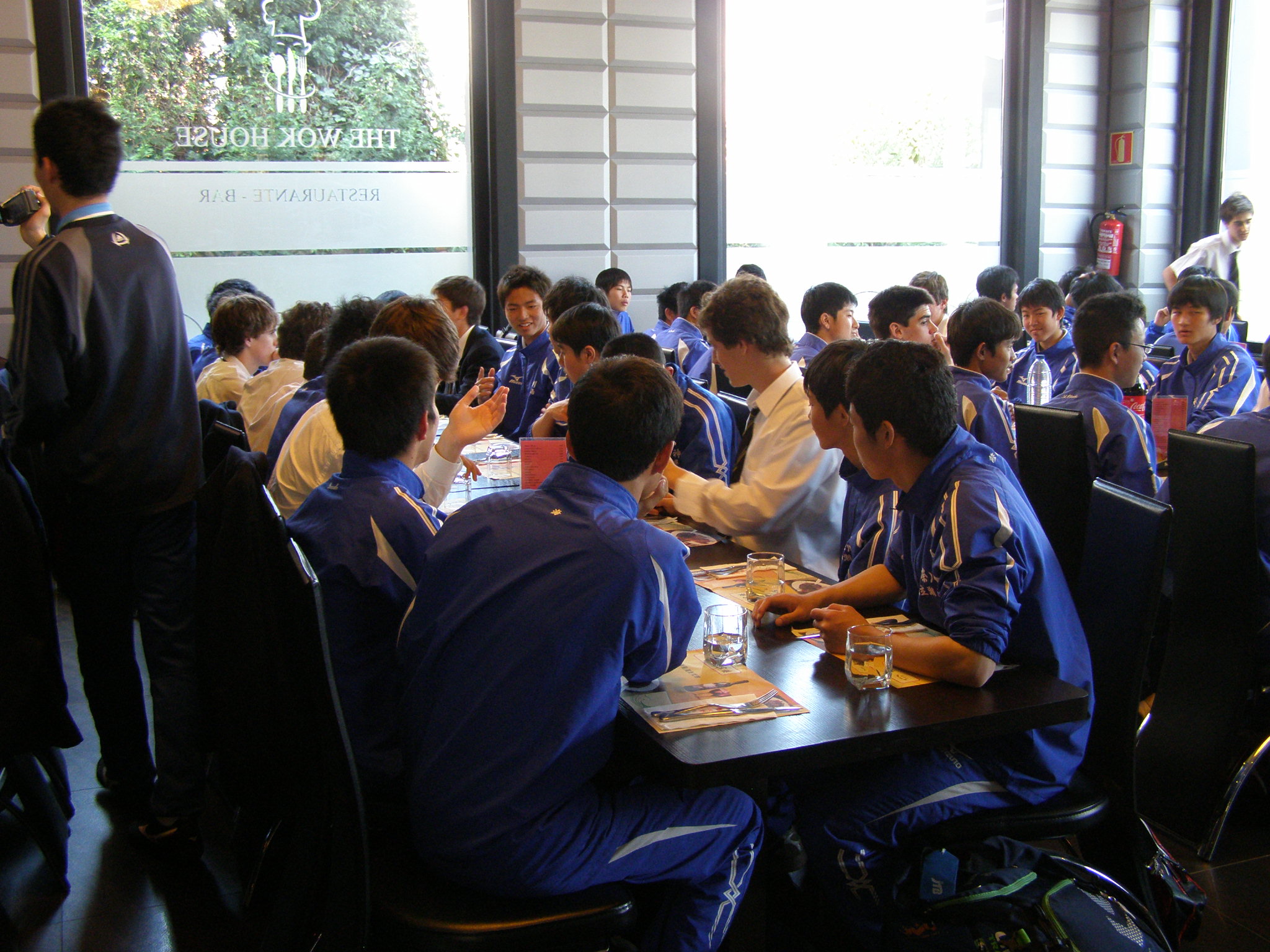 日本とスペインの学校交流、日本とスペインの選手が談笑しながら食事している様子