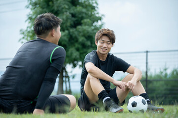 サッカー合宿の合間に座って談笑している選手の様子